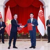 Thủ tướng Phạm Minh Chính và Thủ tướng Singapore Lý Hiển Long chứng kiến lễ trao văn kiện hợp tác giữa hai nước tại Singapore ngày 9/2/2023. (Ảnh: Dương Giang/TTXVN)