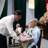 Bí thư Thành ủy Vũng Tàu Trần Đình Khoa tặng hoa cho đảng viên 65 năm tuổi Đảng. (Ảnh: Đoàn Mạnh Dương/TTXVN)