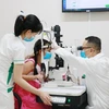 Bác sỹ chuyên khoa II Nguyễn Nam Trung thăm khám cho bệnh nhi đau mắt đỏ tại Bệnh viện Mắt Sài Gòn Nha Trang. (Ảnh: Phan Sáu/TTXVN)