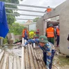 Bộ đội Biên phòng tỉnh Thừa Thiên-Huế phối hợp với chính quyền địa phương hỗ trợ các gia đình bị thiệt hại lợp lại, gia cố mái nhà. (Ảnh: TTXVN phát)