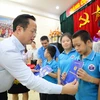 Giám đốc Sở Giáo dục và Đào tạo Hà Nội Trần Thế Cương trao tặng các món quà tới học sinh của 3 ngôi trường chuyên biệt. (Ảnh: Thanh Tùng/TTXVN)