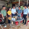 Chủ tịch UBND huyện Bù Đăng Vũ Văn Mười động viên, hỗ trợ gia đình nam thanh niên bị nước lũ cuốn trôi. (Ảnh: Đậu Tất Thành/TTXVN)