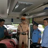 Các lực lượng chức năng tỉnh Quảng Ninh phối hợp kiểm tra kiểm soát xe ôtô vận tải hành khách. (Ảnh: Thanh Vân/TTXVN)