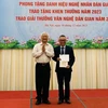 Giáo sư-Tiến sỹ Lê Hồng Lý, Chủ tịch Hội Văn nghệ dân gian Việt Nam, trao giải Nhì A cho tác giả có công trình đạt giải. (Ảnh: Phương Hà/TTXVN )