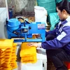 Người dân dùng máy cắt bánh tráng Tân An để đóng gói sản phẩm. (Ảnh: Tá Chuyên/TTXVN)