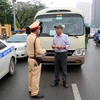 Một trường hợp xe khách đón trả khách sai quy định, đi với tốc độ kiểu “rùa bò” bị lực lượng Phòng Cảnh sát Giao thông, Công an thành phố Hà Nội, dừng xe, kiểm tra và lập biên bản. (Ảnh: Phạm Kiên/TTXVN)
