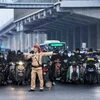 Lực lượng Cảnh sát Giao thông phân luồng các phương tiện để tránh ùn tắc tại ngã tư Nguyễn Xiển-Khuất Duy Tiến-Nguyễn Trãi. (Ảnh: Tuấn Anh/TTXVN)