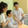  Nhân viên y tế Bệnh viện Đại học Y dược Thành phố Hồ Chí Minh sử dụng máy tính bảng cập nhật và chia sẻ thông tin với người bệnh. (Ảnh: TTXVN phát)