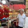Khách du lịch nước ngoài trước hàng bán đồ trang trí Tết tại khu Chinatown ở Bangkok. (Ảnh: Đỗ Sinh/TTXVN)