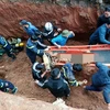 Lực lượng chức năng triển khai công tác cứu nạn cứu hộ đưa nạn nhân lên mặt đất. (Ảnh TTXVN phát)