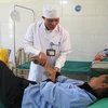 Điều dưỡng Mào Văn Hương chăm sóc sức khỏe cho bệnh nhân tại Trung tâm Y tế huyện Tủa Chùa, tỉnh Điện Biên. (Ảnh: Phan Quân/TTXVN)