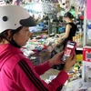 Người dân quét mã QR thanh toán không dùng tiền mặt tại chợ Phù Cát, thị trấn Ngô Mây, tỉnh Bình Định. (Ảnh: Lê Ngọc Phước/TTXVN)