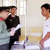 Công an đọc lệnh bắt tạm giam Phan Đình Sang. (Ảnh: TTXVN phát)