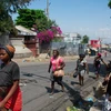 Người dân chạy trốn khỏi khu vực xảy ra đụng độ ở Port-au-Prince, Haiti ngày 20/3 vừa qua. (Ảnh: AFP/TTXVN)