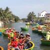 Du khách ngồi trên các chiếc thuyền thúng do người dân địa phương chèo để tận hưởng vẻ đẹp sông nước. (Ảnh: Thúy Lan/Vietnam+)