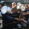 Người dân xếp hàng tại một điểm phân phát thức ăn cứu trợ tại Gaza ngày 14/3 vừa qua. (Ảnh: THX/TTXVN)
