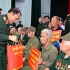 Thượng tướng Phùng Sĩ Tấn, Phó Tổng Tham mưu trưởng QĐND cùng đoàn công tác trao tặng quà cho các cựu chiến binh và gia đình chính sách tỉnh Điện Biên. (Ảnh: Trung Kiên/TTXVN)