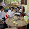 Lãnh đạo tỉnh Quảng Bình thăm hỏi các ngư dân được cứu sống trở về địa phương. (Ảnh: TTXVN phát)
