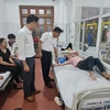 Giám đốc Sở Y tế tỉnh Vĩnh Phúc Lê Hồng Trung thăm hỏi, kiểm tra sức khỏe công nhân bị ngộ độc thực phẩm đang được điều trị tại Trung tâm y tế thành phố Vĩnh Yên. (Ảnh: Nguyễn Thảo/TTXVN)
