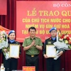 Thượng tướng Lương Tam Quang, Thứ trưởng Bộ Công an trao Quyết định của Chủ tịch nước cho 2 sỹ quan Công an Nhân dân đi thực hiện nhiệm vụ gìn giữ hòa bình Liên hợp quốc. (Ảnh: TTXVN phát)