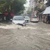 Khu vực Vĩnh Hưng, quận Hoàng Mai, các phương tiện tham gia giao thông gặp khó khăn khi mưa lớn và sấm sét liên tục. (Ảnh: Phạm Tuấn Anh/TTXVN)