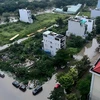 Một khu dân cư trên đường Nguyễn Lương Bằng, quận 7, TP Hồ Chí Minh, bị bao quanh bởi “biển nước” do mưa lớn và triều cường. (Ảnh: Thu Hương/TTXVN)