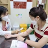 Bác sỹ Bệnh viện Da liễu Thành phố Hồ Chí Minh khám bệnh cho người dân bị viêm da do độc tố của kiến ba khoang. (Ảnh: TXVN phát)