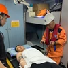 Lực lượng Trung tâm Phối hợp tìm kiếm, cứu nạn hàng hải Việt Nam khu vực IV kiểm tra sức khỏe của bệnh nhân trước khi tiếp nhận đưa về đất liền. (Ảnh: TTXVN phát)