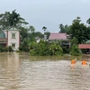 Lực lượng chức năng khẩn trương tiếp cận, di dời người dân và tài sản đến nơi an toàn. (Ảnh: Tạ Toàn/TTXVN)