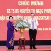 Ông Nguyễn Phước Lộc, Phó Bí thư Thành ủy, Chủ tịch Ủy ban Mặt trận Tổ quốc Việt Nam Thành phố Hồ Chí Minh tặng hoa chúc mừng Giáo sư Nguyễn Thị Ngọc Phượng. (Ảnh: Đinh Hằng/TTXVN)