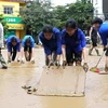 Hàng trăm người gồm bộ đội, công an, dân quân tự vệ, đoàn thanh niên... được huy động hỗ trợ dọn bùn, giúp người dân thành phố Yên Bái sớm ổn định cuộc sống sau đợt lũ. (Ảnh: Tuấn Anh/TTXVN)