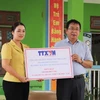 Phó Tổng giám đốc TTXVN Nguyễn Tuấn Hùng trao tặng số tiền 100 triệu đồng của TTXVN hỗ trợ Trường Mầm non Hoa Lan, phường Hồng Hà, thành phố Yên Bái khắc phục thiệt hại của bão số 3. (Ảnh: Tiến Khánh/TTXVN)