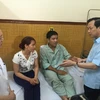 Bộ trưởng Đào Ngọc Dung hỏi thăm sức khỏe Thiếu tá phi công Nguyễn Hữu Cường. (Ảnh: Hồng Kiều/Vietnam+)