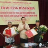 Bộ trưởng Đào Ngọc Dung tặng bằng khen cho hai lão nông ở Bắc Ninh. (Ảnh: PV/Vietnam+)