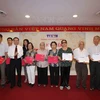 Tổng Giám đốc Thông tấn xã Việt Nam Nguyễn Đức Lợi trao sổ tiết kiệm cho các thân nhân gia đình liệt sỹ. (Ảnh: Quý Trung/TTXVN)