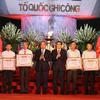 Thủ tướng Nguyễn Xuân Phúc trao bằng Tổ quốc ghi công cho thân nhân các gia đình liệt sỹ. (Ảnh: Thống Nhất/TTXVN)