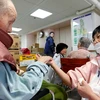 Điều dưỡng viên hỗ trợ người cao tuổi tại Tomioka, tỉnh Fukushima, Nhật Bản. (Ảnh minh hoạ: AFP/TTXVN)