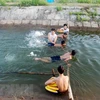 Hướng dẫn trẻ em kỹ năng bơi lội. (Ảnh: Thanh Thủy/TTXVN)