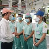 Tổng Giám đốc Bảo hiểm xã hội Việt Nam Nguyễn Thế Mạnh kiểm tra việc hỗ trợ người lao động tại Công ty ToTo Việt Nam. (Ảnh: PV/Vietnam+)