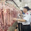 Đoàn kiểm tra Ban Quản lý an toàn thực phẩm Thành phố Hồ Chí Minh kiểm tra thịt lợn nhập về chợ đầu mối nông sản thực phẩm Hóc Môn. (Ảnh: TTXVN phát)
