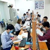 Giải quyết thủ tục nhận trợ cấp thất nghiệp cho người lao động. (Ảnh: PV/Vietnam+)