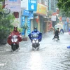 Lái xe máy trong thời tiết mưa lớn, ngập lụt tiềm ẩn nhiều nguy hiểm, rủi ro với các tài xế. (Ảnh minh họa: PV/Vietnam+)
