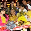 Các nghệ sỹ tặng hoa chúc mừng giáo sư Trần Văn Khên tròn 90 tuổi. (Ảnh: TTXVN)