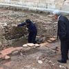 Phó giáo sư-tiến sỹ Tống Trung Tín (trái) giới thiệu về các dấu tích mới phát lộ tại các hố khai quật trong năm 2016. (Ảnh: An Ngọc/Vietnam+)