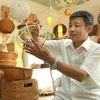 Nghệ nhân Nguyễn Văn Trung - làng nghề truyền thống Phú Vinh đang làm các sản phẩm mây tre đan. (Ảnh minh họa: TTXVN)