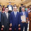 Thủ tướng Nguyễn Xuân Phúc với Phó Tổng giám đốc TTXVN Lê Quốc Minh và các tác giả đạt giải B (thể loại ảnh) thuộc Ban Biên tập Ảnh TTXVN. (Ảnh: Minh Quyết/TTXVN)