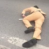 Cú đâm mạnh khiến Trung úy cảnh sát bị thương, nằm bất động trên đường. (Ảnh: PV/Vietnam+)