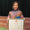 Cô Ghếnh nhận bằng khen Nhà giáo tiêu biểu giai đoạn 2008-2013. (Ảnh: Phạm Mai/Vietnam+)