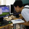 Kỹ thuật viên kiểm tra máy tính lần cuối trước khi kỳ thi bắt đầu. (Ảnh: Đại học Quốc gia Hà Nội) 
