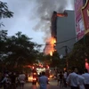 Nhiều người dân hiếu kỳ đã xuất hiện tại hiện trường vụ cháy quán karaoke. (Nguồn: Vietnam+)
